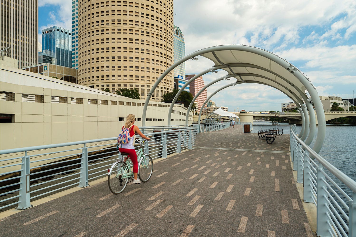 Women riding a bike across the Tampa Florida riverwalk