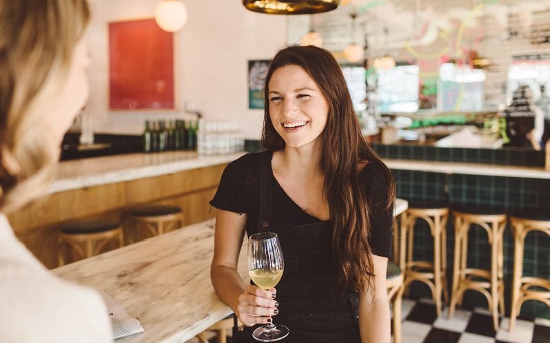 lady smiling holding a glass of wine 