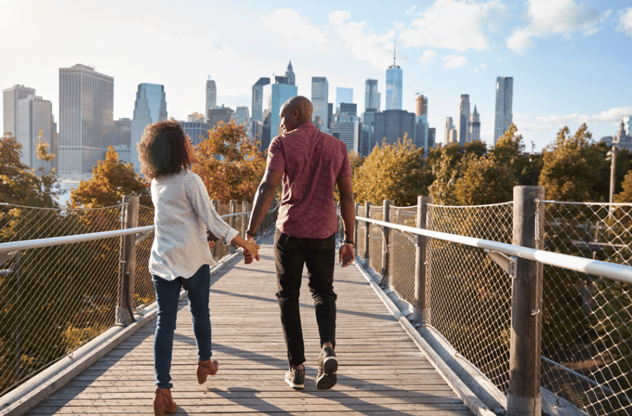 A postpartum travel nurse holding hands while walking over a bridge